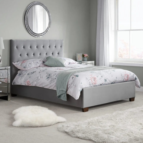 Chiswick Bed: A modern masterpiece of elegance and comfort, featuring a stylish buttoned headboard and versatile upholstery options in steel crushed velvet or sophisticated grey fabric. Explore the ottoman bed frame option for added functionality. Available in sizes Double bed and King Size Bed - Lifestyle Image