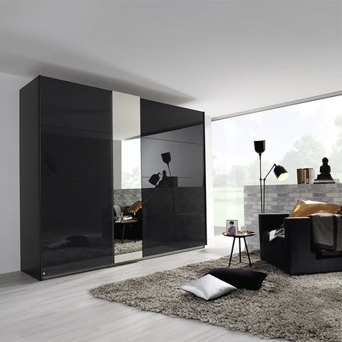 Rauch Graphite Perth Sliding Door Wardrobe, features 2 sliding doors with colour glass fronts, adding a touch of elegance to your bedroom. Available in three chic colours: White, Silk Grey, and Graphite. One of the doors is equipped with mirror pads, and you have the option to add an optional LED light that surrounds the mirror pads. Dimensions: Small: Width 181cm, Height 223cm, Depth 68cm, Medium: Width 226cm, Height 223cm, Depth 68cm, Large: Width 271cm, Height 223cm, Depth 68cm - Lifetsyle Image 2