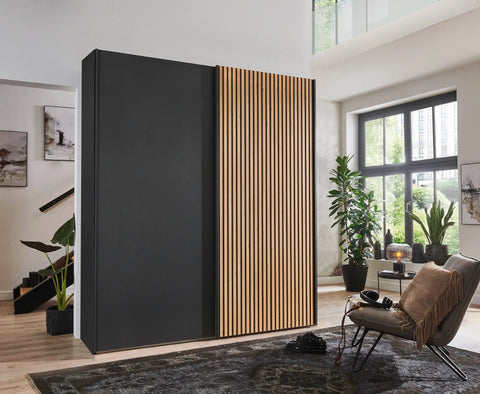 Tulsa 2 Door Black Sliding Door Wardrobe showcased in graphite colour with a Bianco Oak slated structure door. Modern design with free delivery and assembly by Wiemann. - Lifestyle Image