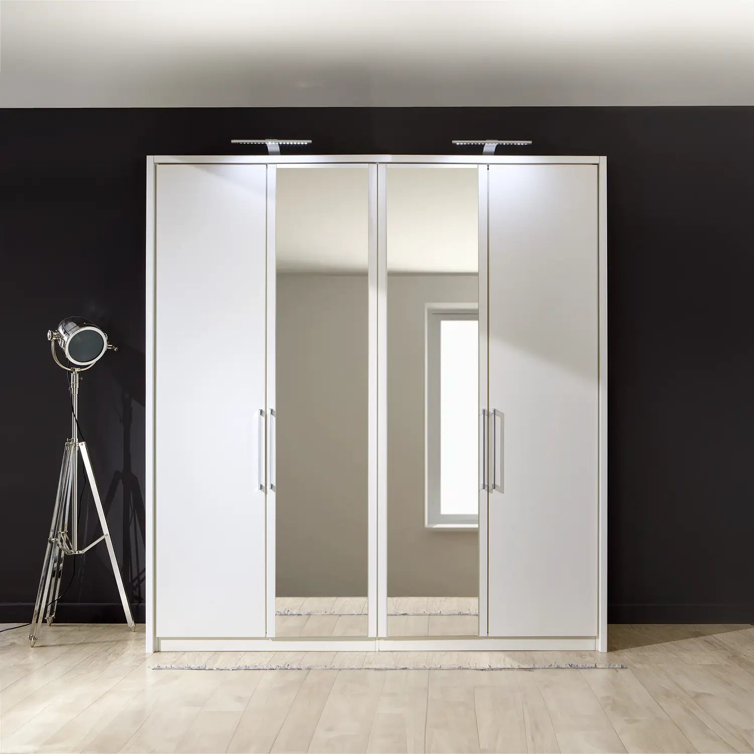 Image of Wiemann Bristol White 4 Door Wardrobe with Mirror. Option of Matt or Glass finish on side doors, with middle doors featuring mirror pads. Dimensions: Width 200cm, Height 216cm, Depth 58cm. Free Delivery and Assembly. 12 months interest-free pay monthly available. - Front View Lifestyle Image